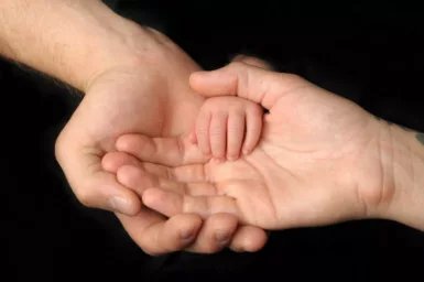 Gens qui tiennent la main d'un bébé