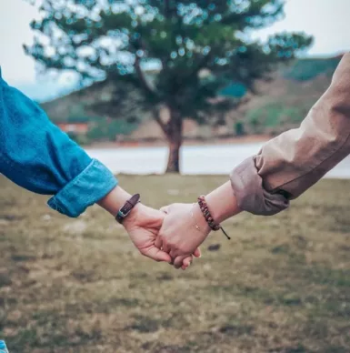 two persons holding hands